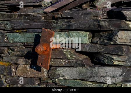 Detailed view of a rusted metal wall tie fixing on stacked slate walling at Dorothea Quarry Stock Photo