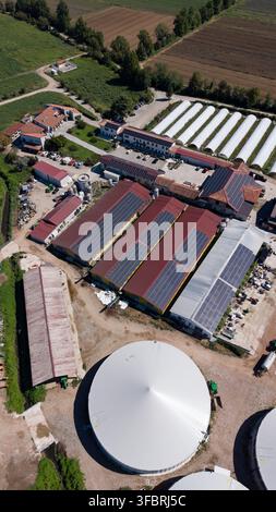 Aerial view of large greenhouses with a circular water tank and solar ...