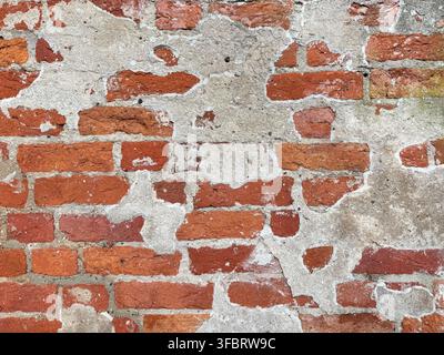 Old red brick wall texture with peeling plaster Stock Photo