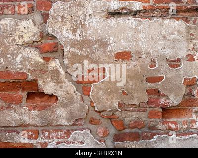 Old red brick wall texture with peeling plaster Stock Photo