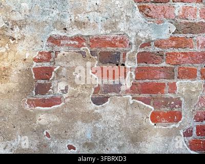 Old red brick wall texture with peeling plaster Stock Photo