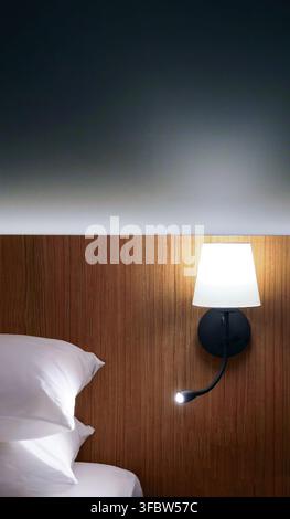 Set of hotel bedroom interior photos. Features clean white pillows on a bed against a modern wooden headboard. Includes a dark wall with ambient light Stock Photo
