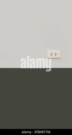 A standard white double electrical power outlet installed on a minimalist interior wall. The wall features a two tone color block design with light gr Stock Photo