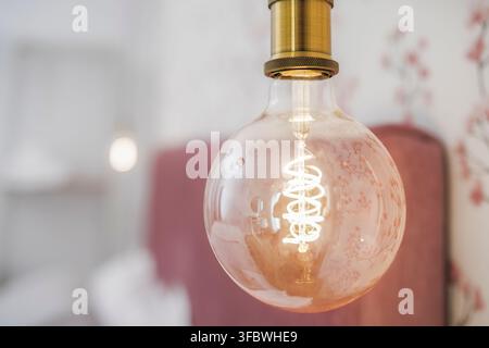 Vintage Edison bulb glowing inside a warm interior Stock Photo