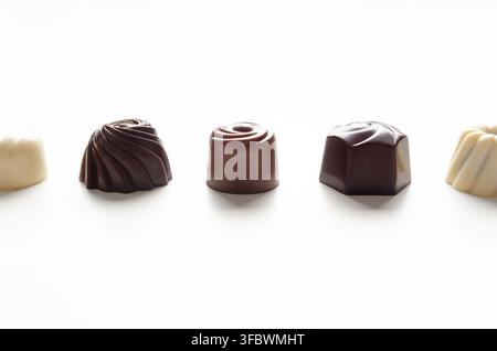 Assorted chocolate bonbons on white background. Chocolate day concept. Front view with copy space. Stock Photo