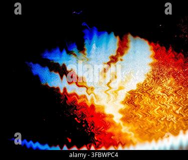 Abstract image with wavy patterns of blue white red orange and yellow on a black background Stock Photo