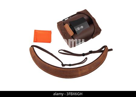 Modern rangefinder binoculars with leather strap, case, and cleaning cloth on white background. Stock Photo