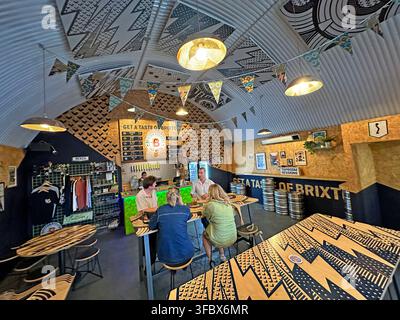 Interior of Brixton Brewery tap room in London, with customers drinking craft beer and ales. Stock Photo