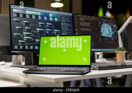 Close up of green screen mockup laptop in AI tech company workspace used to conduct code reviews and fix bugs. Chroma key notebook on office desk used to design and implement deep learning algorithms Stock Photo