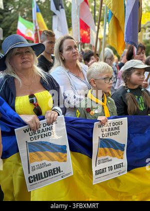 London, UK. 24 August 2026. Adults and children hold a large Ukrainian flag and placards during a gathering at the St Volodymyr Monument on Holland Park Avenue marking the 35th anniversary of Ukraine’s independence. Credit: Alexander Seale/Alamy Live News Stock Photo