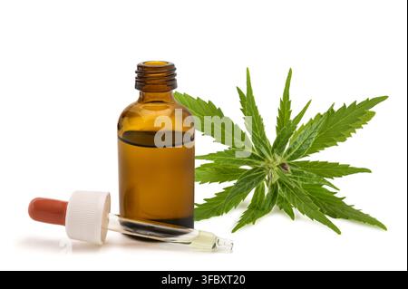Cannabis essential oil in an amber glass dropper bottle with fresh cannabis leaves, isolated on a white background. High-quality botanical and herbal Stock Photo