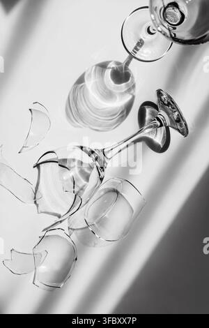 Elegant monochrome still life of shattered wine glass fragments and reflections. Concept of fragility, impermanence, risk and uncertainty Stock Photo