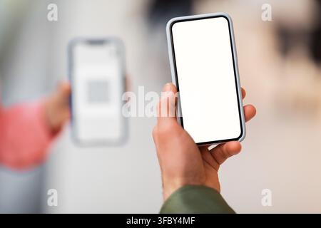 Two Hands Holding Smartphones With Empty Screens, Digital Interaction Concept Stock Photo