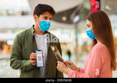 Man And Woman Using Smartphone And Tablet With Qr Code For Check-in At Mall, Healthcare Concept Stock Photo