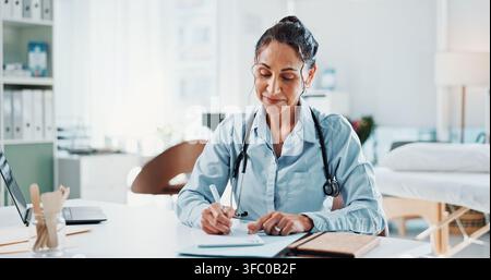 Doctor, woman and writing in office with notepad, healthcare tasks and reminder for administration. Happy, mature person or medical worker taking Stock Photo