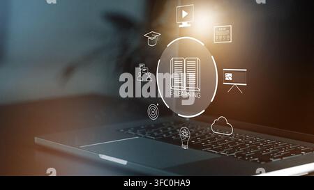 E learning tools and resources on a laptop screen displaying various icons in a modern workspace Stock Photo