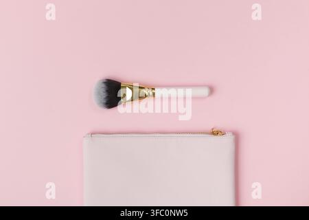 Makeup brush and cosmetic bag on a pink background Stock Photo