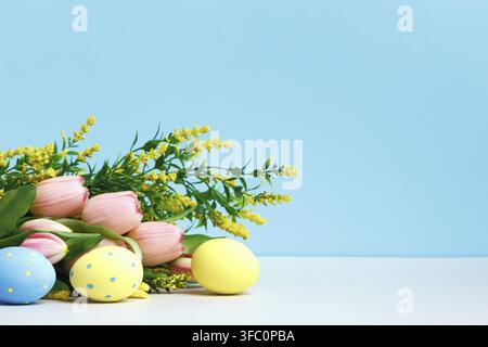Spring composition. Blooming branch flowers tulips easter eggs on the table Stock Photo
