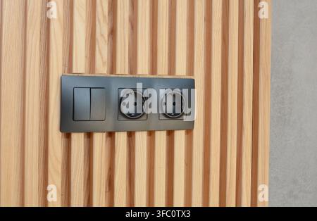 Electrical outlet light switch on wooden wall Stock Photo