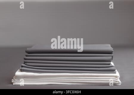 A stack of folded clean gray and white sheets Stock Photo