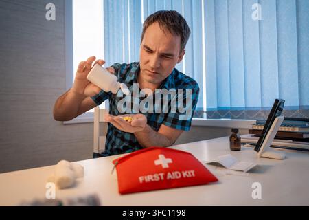 First aid kit, a set of various medicines collected in a red bag, pills for pain, an elastic bandage, a man holds a first-aid kit in his hands, hiking Stock Photo