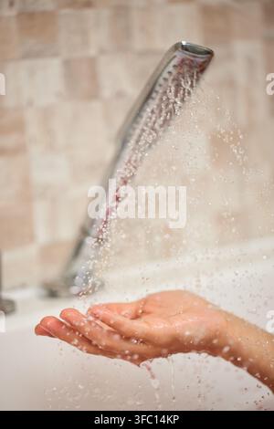 Hand catching fresh water from shower Stock Photo