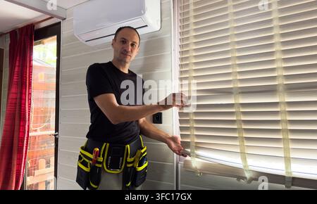 Male hands installing roller blinds on window  Stock Photo