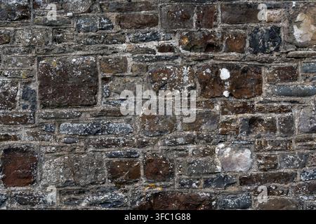 Rough old granite stone wall for use as a background texture Stock Photo