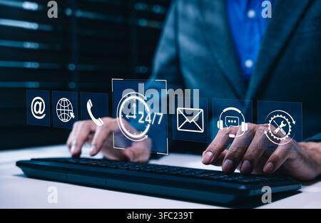Customer support and 24/7 service concept. professional using computer keyboard, surrounded by icons for email, phone, global communication, help desk Stock Photo