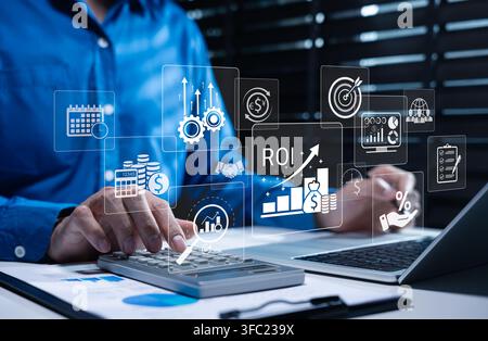 Analyzing ROI and Business Strategy Concepts. Businessman working on laptop with various digital icons representing ROI, financial strategies, marketi Stock Photo