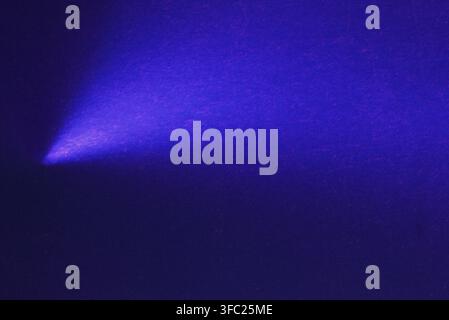 Electric blue light beam on dark texture creating a powerful focused mood. Stock Photo