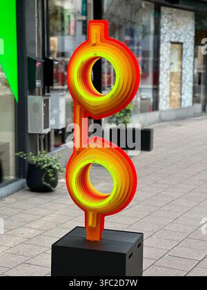Vibrant abstract modern art sculpture with nested concentric circles on a city street. Striking contemporary street art sculpture featuring layered co Stock Photo