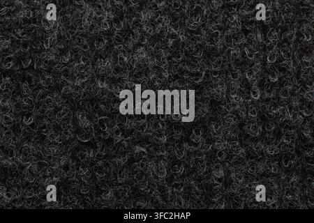 Macro close up texture dark curly synthetic wool or loop pile carpet fibers background pattern Stock Photo