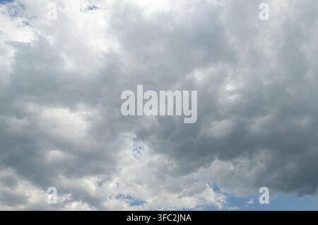 A vast expanse of dramatic grey and white storm clouds filling the sky, creating a moody, contemplative, and powerful natural atmosphere. Stock Photo