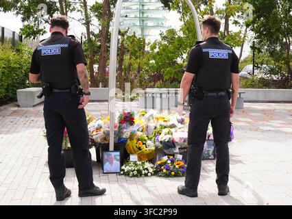 Police officers look at flowers at the Cleveland Police HQ in Middlesbrough, following the line-of-duty deaths of PC Matthew Blades and PC Tom Clough who died when a car going in the wrong direction hit a police car on the A66 near Middlesbrough. Picture date: Tuesday August 25, 2026. Stock Photo