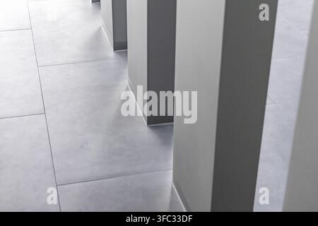 A minimalist architectural perspective of a contemporary hallway featuring large format tiles and repeating vertical elements Stock Photo