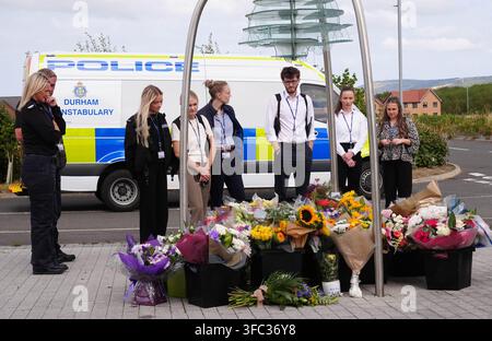 Police officers look at flowers at the Cleveland Police HQ in Middlesbrough, following the line-of-duty deaths of PC Matthew Blades and PC Tom Clough who died when a car going in the wrong direction hit a police car on the A66 near Middlesbrough. Picture date: Tuesday August 25, 2026. Stock Photo
