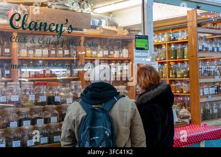 Middle-aged couple looking into the window of a spice and herb shop in Cardiff indoor marketplace, South Wales, UK Stock Photo