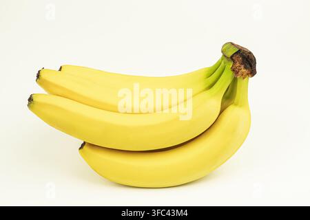 Ripe yellow bananas arranged naturally on a plain white background, soft even lighting, smooth glossy texture, appealing composition, bright and clean Stock Photo