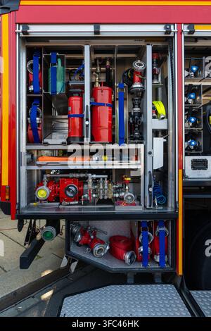 Firefighting equipment stored in response vehicle, with coiled hoses, water distribution components prepared for operation. Fire safety, emergency ser Stock Photo