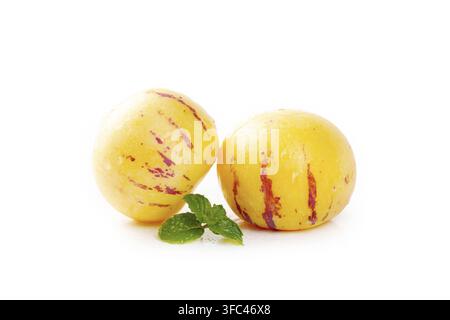 Two pepino melons with mint leaves isolated on a white background. Stock Photo