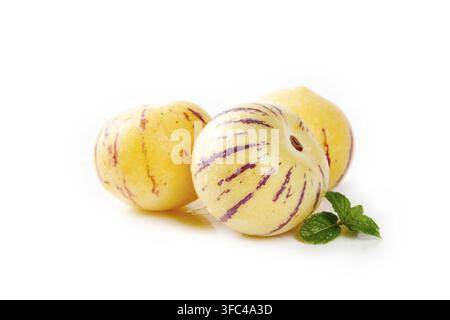 Pepino melons with mint leaves isolated on a white background. Stock Photo