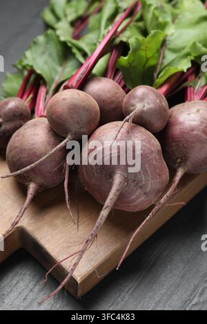 Many young beets with green leaves on dark textured table, closeup Stock Photo