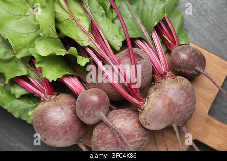 Many young beets with green leaves on dark textured table, top view Stock Photo