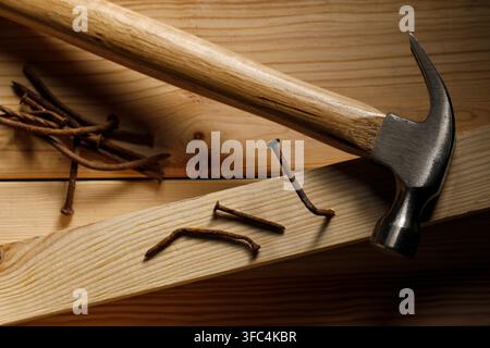 Rusty metal nails, plank and hammer on wooden table, flat lay Stock Photo