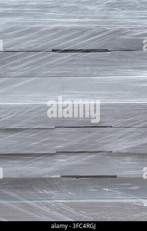 Stack of cardboard boxes wrapped in clear plastic film texture background. Stock Photo