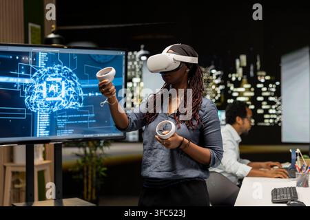 Engineer using virtual reality technology to write code, developing deep learning APIs. Tech startup worker using VR headset to troubleshoot software errors using artificial intelligence Stock Photo
