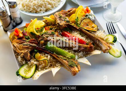 Lamb ribs with white rice, hummus and grilled vegetables Stock Photo