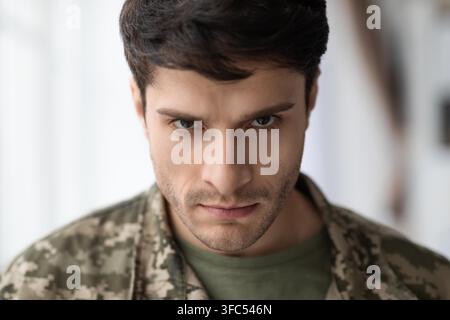 Focused Young Caucasian Man In Military Uniform Displaying Serious Expression, Healthcare Concept Stock Photo