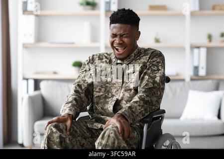 Smiling Black Man In Wheelchair Wearing Military Uniform, Home, Healthcare Concept Stock Photo